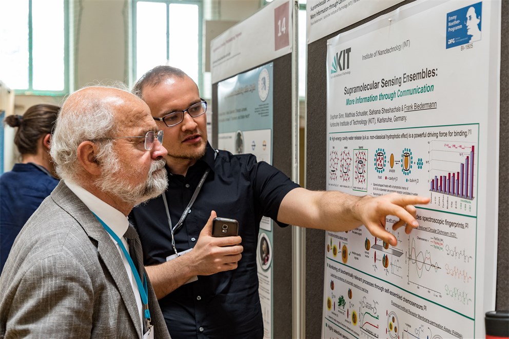Erwin Neher discussing with a young scientist at the poster session